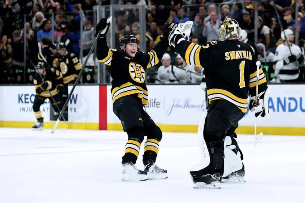 Fraser Minten and Jeremy Swayman are pictured celebrating a win in March.